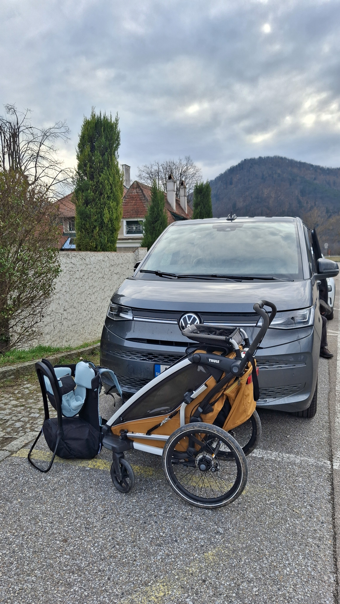 Odparkovaný Multivan T7 na parkovisku v Durnstein a pred ním Thule Sapling detský nosič a Thule Chariot Sport 2 cyklovozík