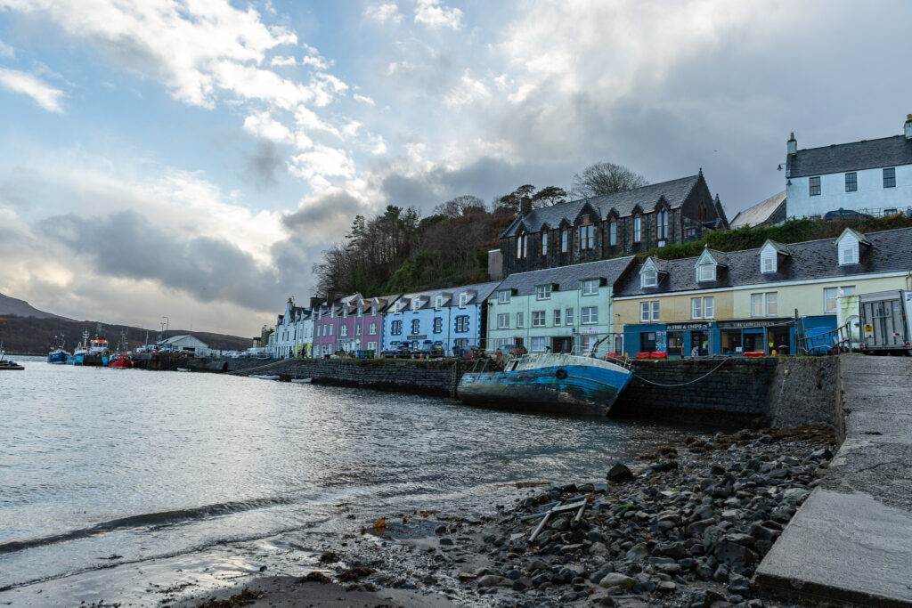 Portee hlavné mesto na ostrove Skye. Odfotená zátoka s farebnými domami a loďou. Škótsko.