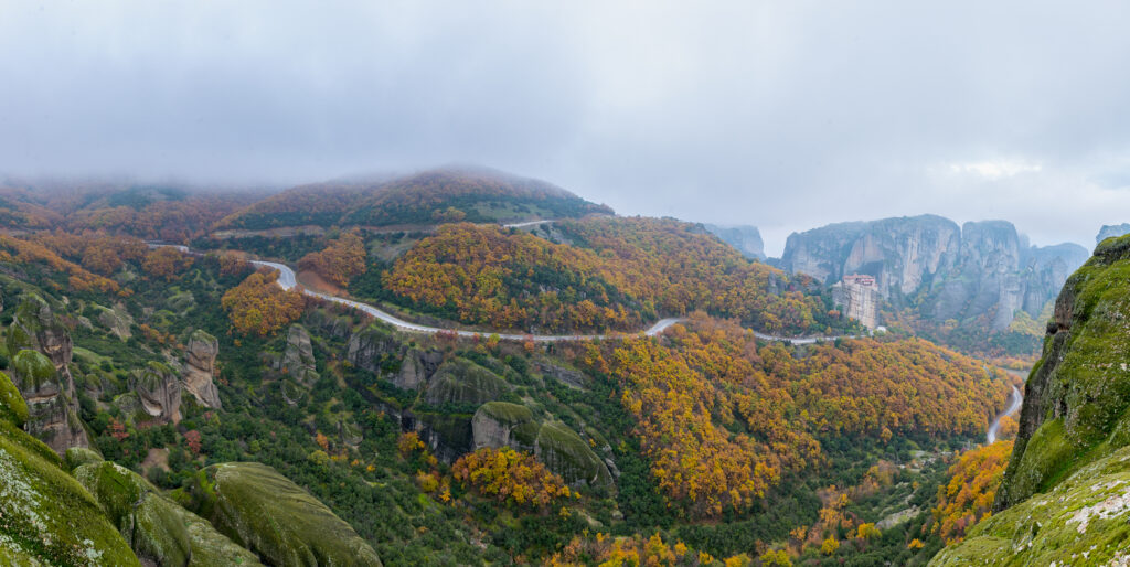 Pohľad na Grécku Meteoru. Jesenné farebné stromy a jemne zatiahnutá obloha.