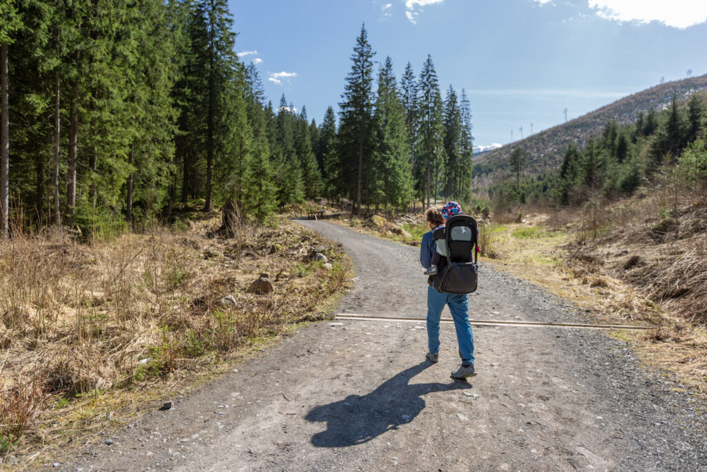 Turista kráča s nosičom Thule na chrbe dolinou Zadnej vody v Demänovskej doline.