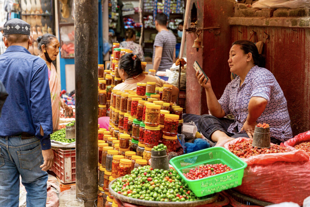 Unudená predavačka predáva nakladanú zeleninu v pohároch v Thameli v Káthmandu