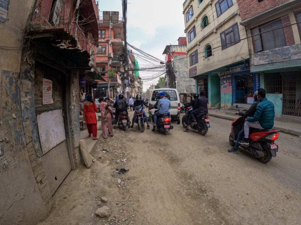 Prašná ulica v Káthmandu s miestnou dopravou