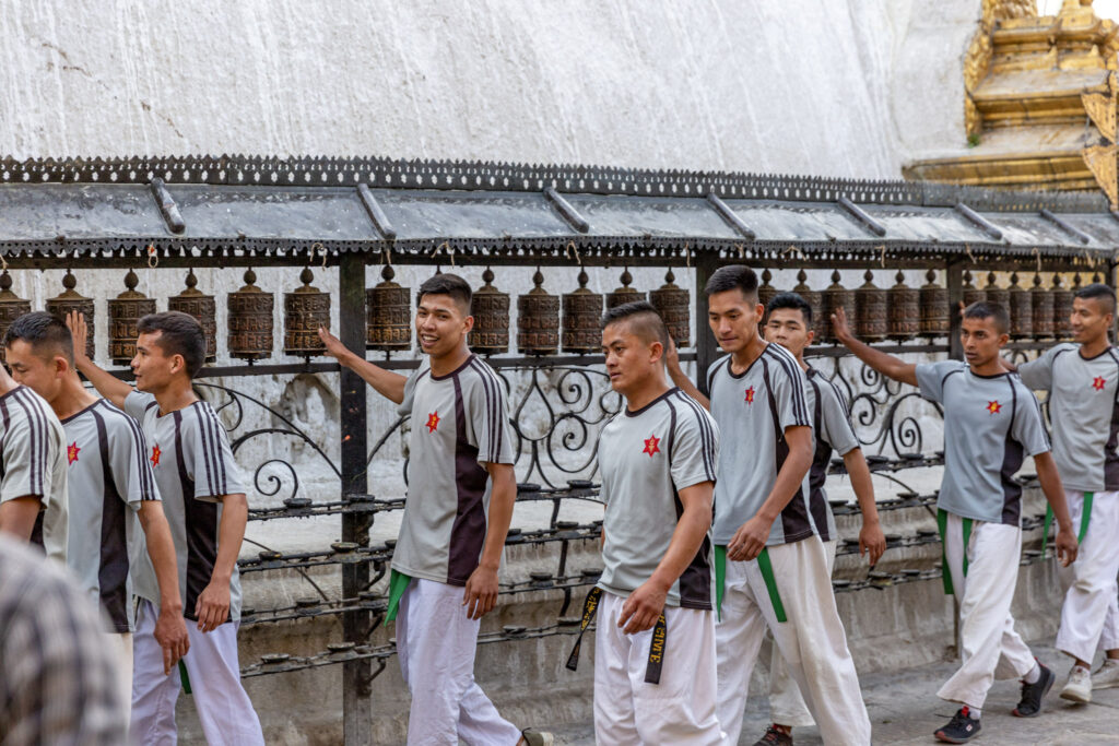 Mladí muži roztáčajú modlitebné mlynčeky v Swayambhunath v Káthmandu