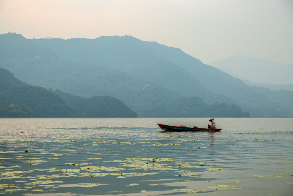 Rybár na tradičnej loďke, jazero Phewa, Pokhara