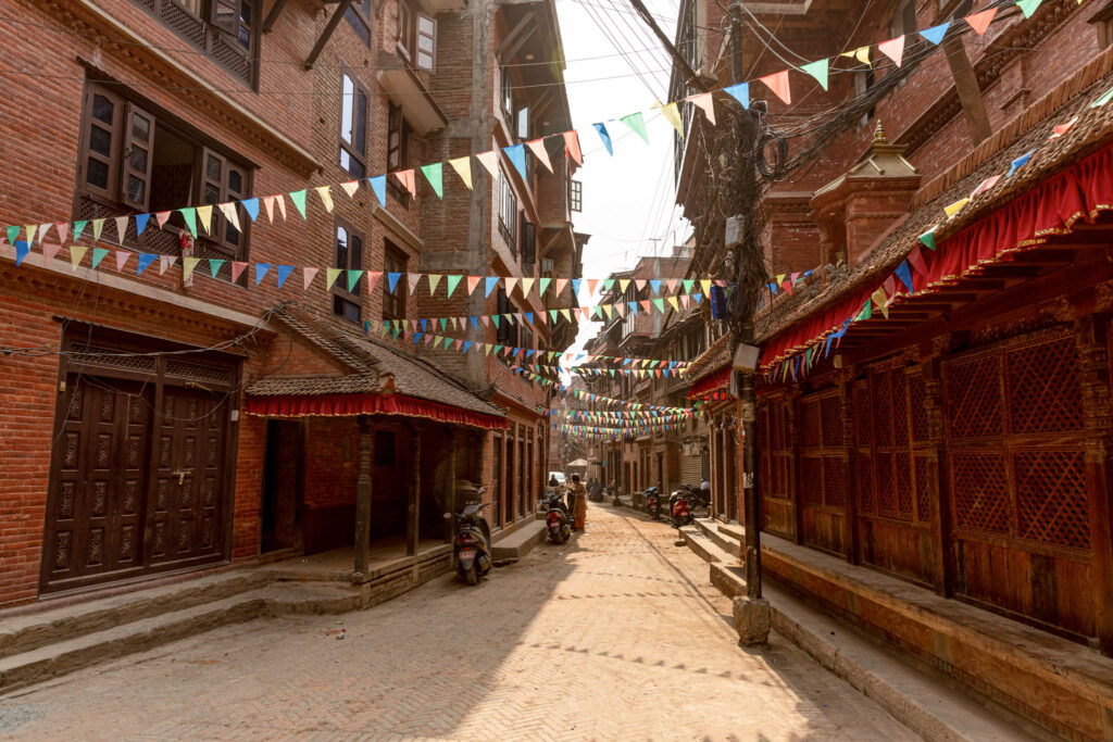 Červená tehlová ulica v Bhaktapur s farebnými vlajočkami