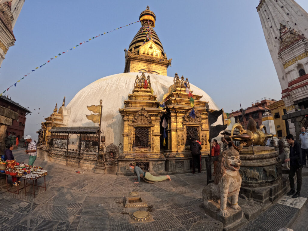 Žena vykonávajúca rituálne obchádzanie stúpy ľahaním si na zem v Swayambhunath v Káthmandu