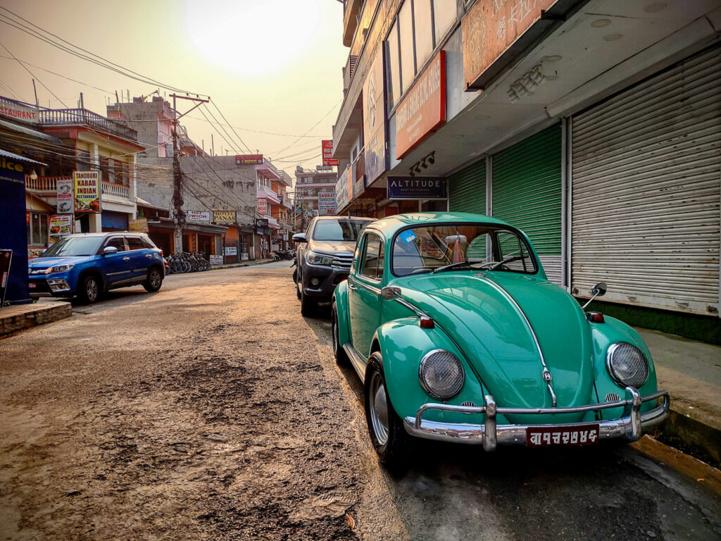 V popredí staré zelené auto, Volkswagen Beetle na ulici v Lake Side, Pokhara, Nepál