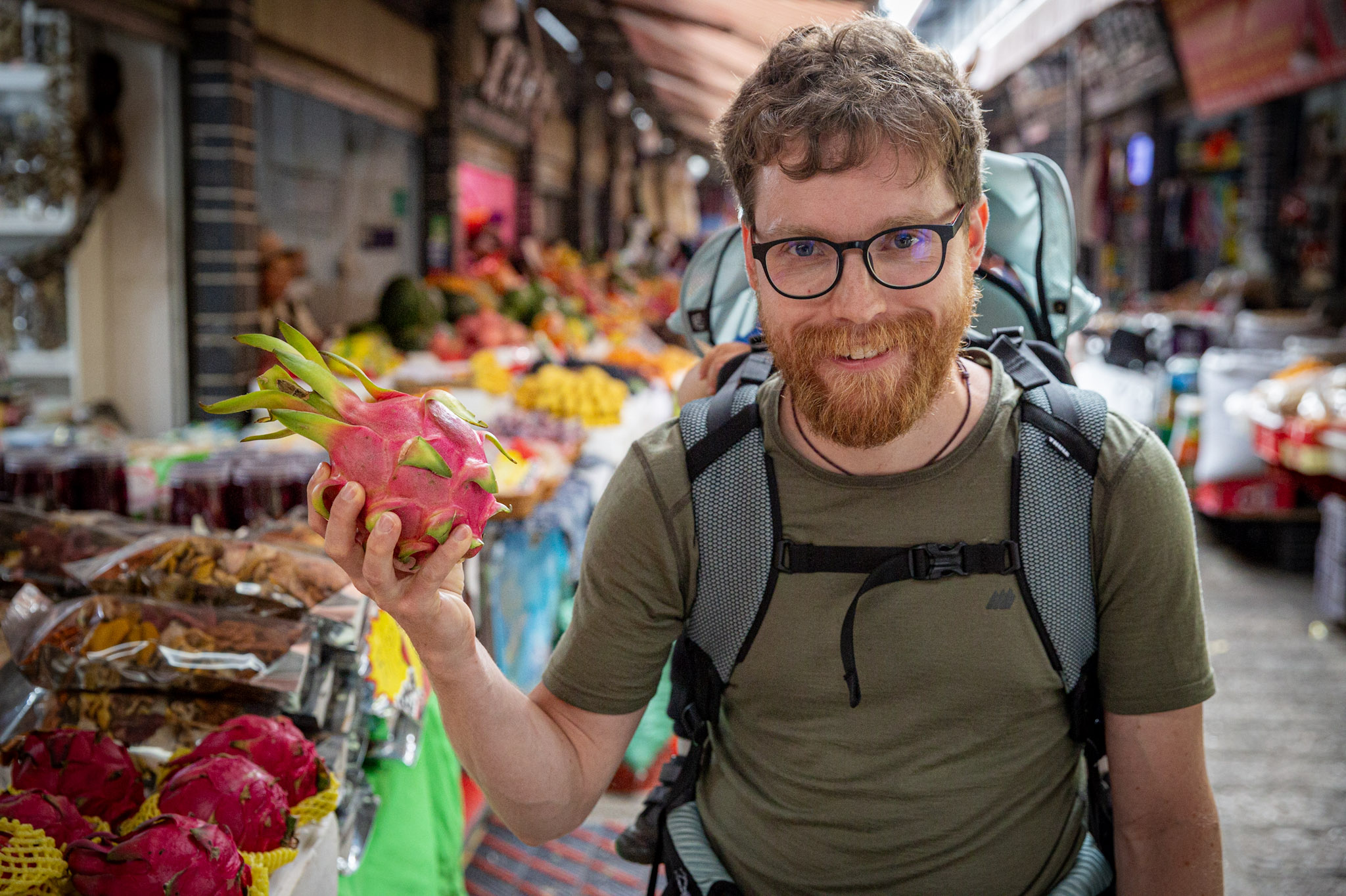 Muž držiaci dračie ovocie na tradičnom trhu, Lijiang