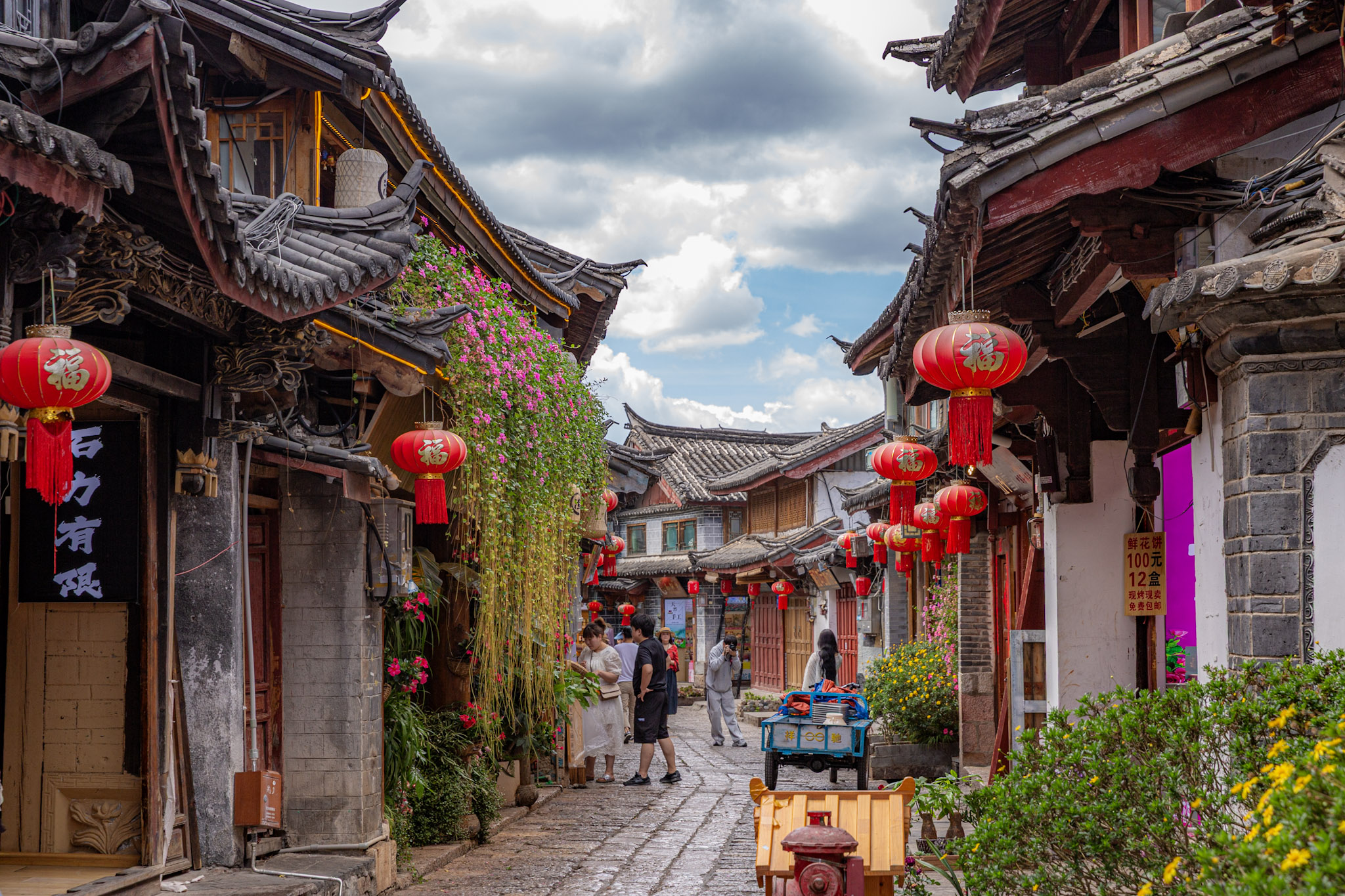 Historická kamenná ulička lemovaná červenými lampiónmi v starom meste, Lijiang, Čína