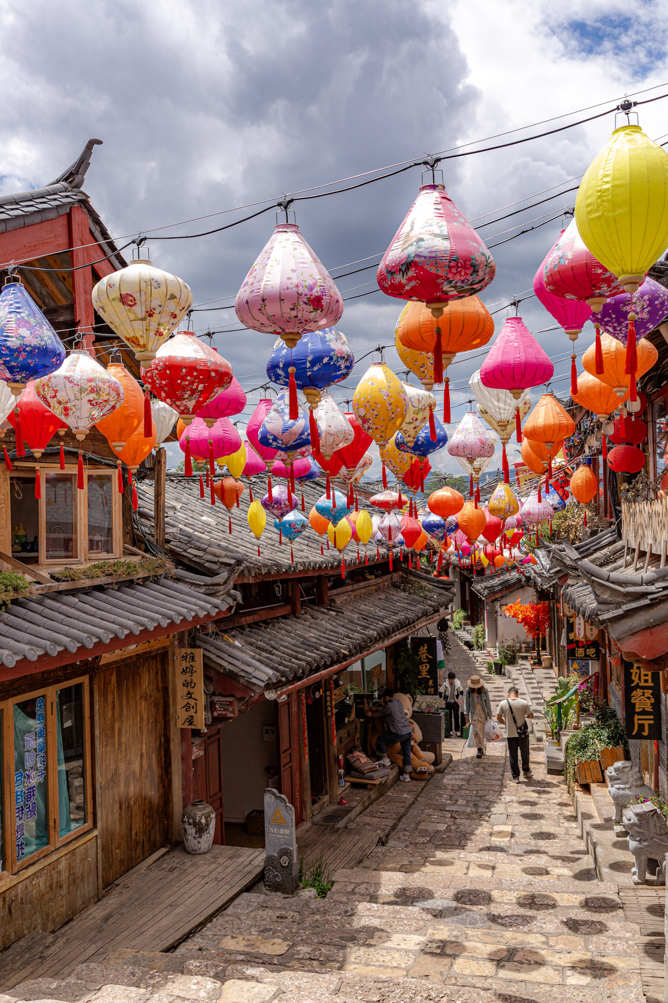 Ulička v starom meste Lijiang vyzdobená desiatkami visiacich farebných lampiónov.