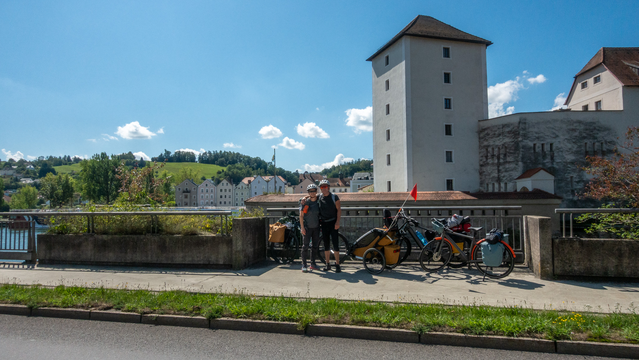 Cyklisti pri bicykloch a v pozadí časť mesta Passau