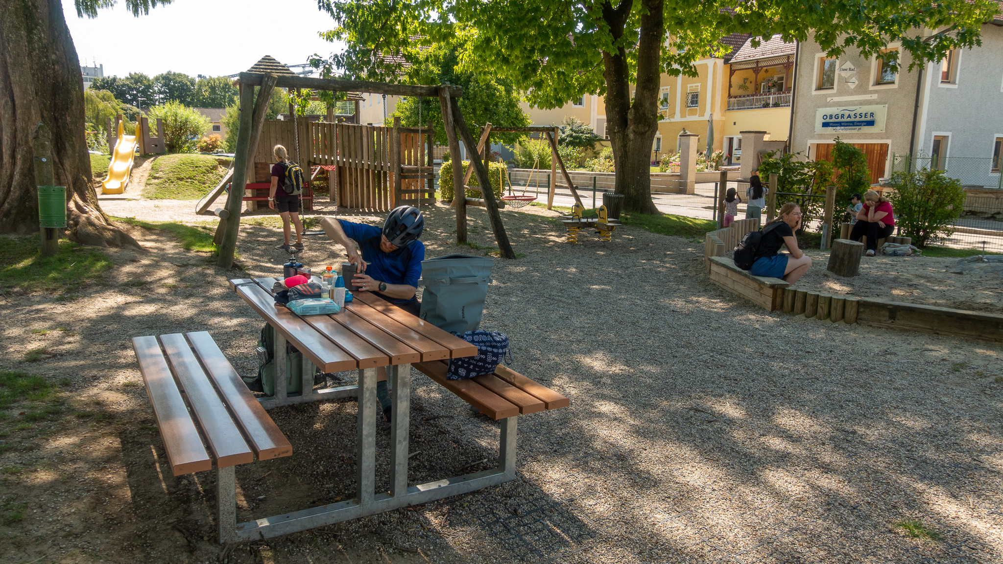 Detské ihrisko a cyklista na lavičke ktorý pripravuje obed na variči