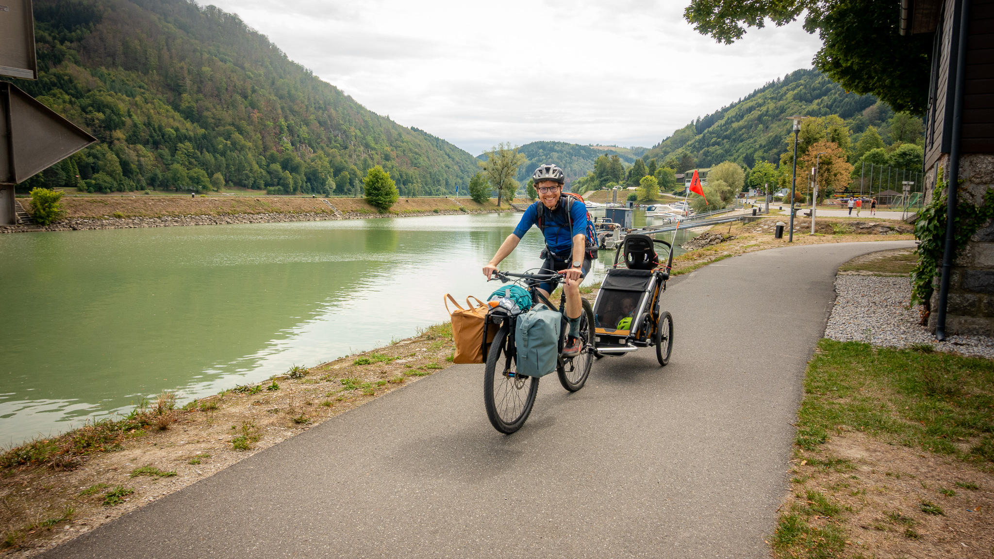 Cyklista s cyklovozíkom za sebou pri Dunaji