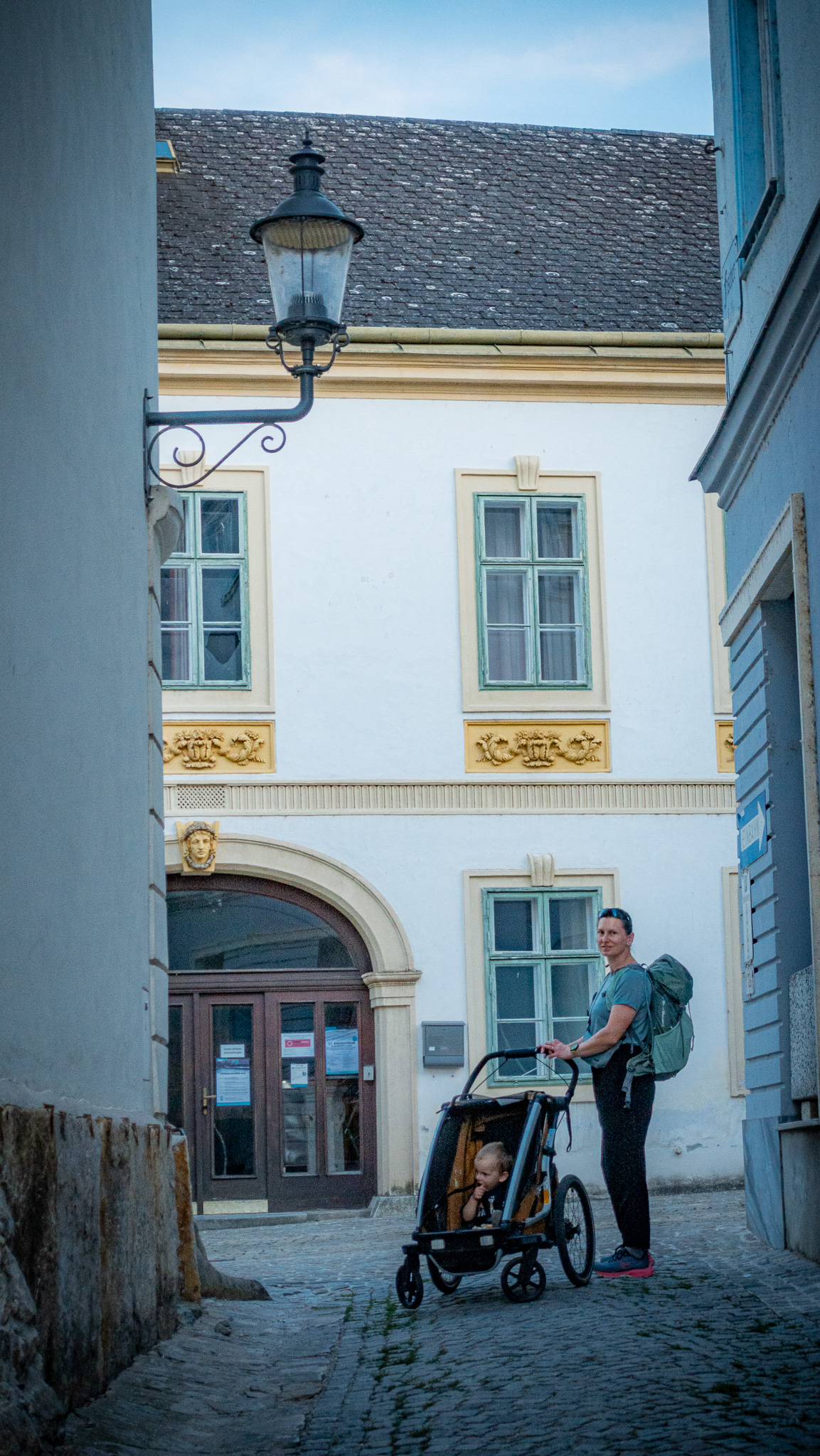 Matka so synom v cyklovozíku Thule na prechádzke po meste pešo