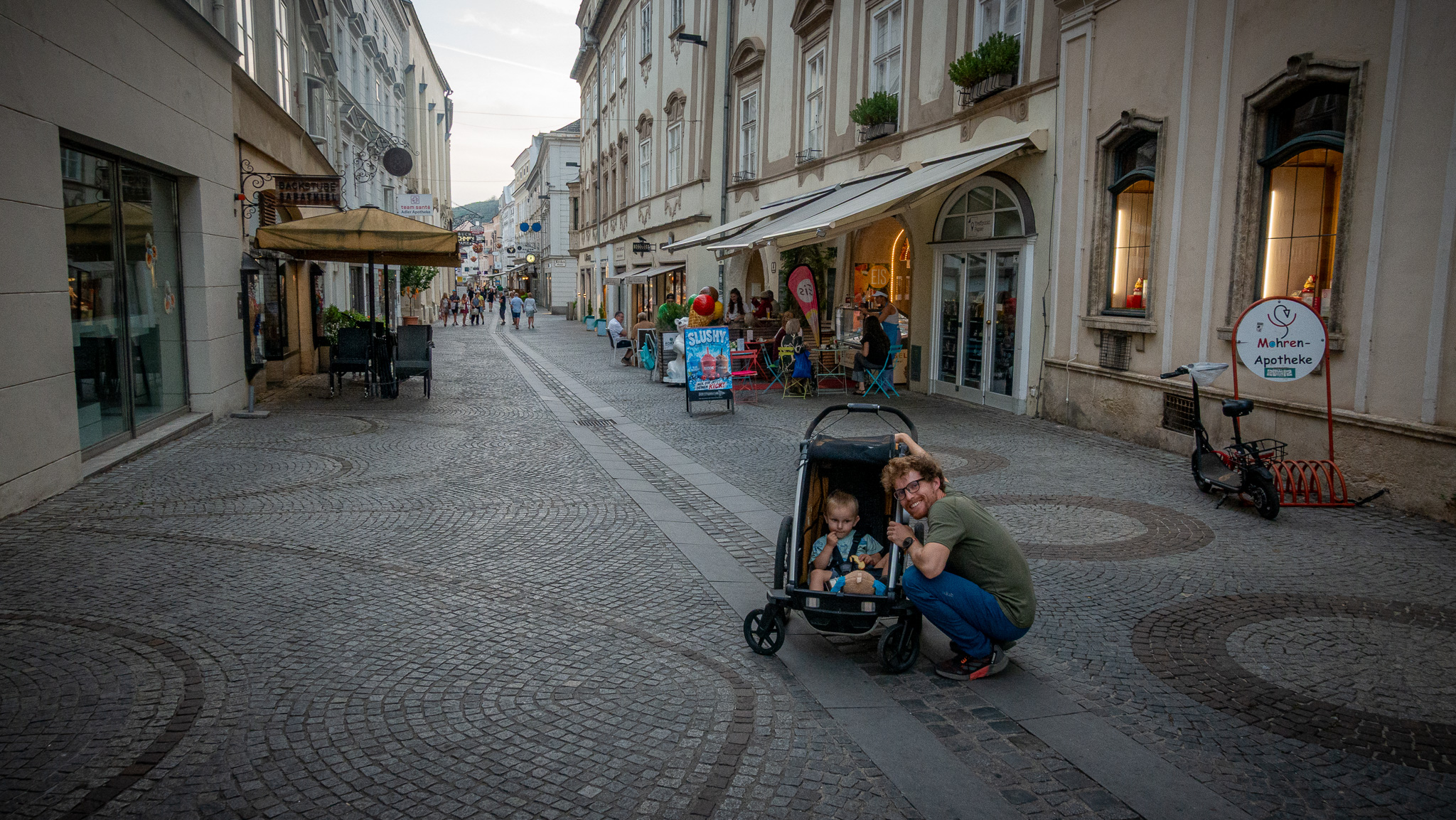 Turista so synom v cyklovozíku Thule Chariot Sport 2 v uliciach mesta