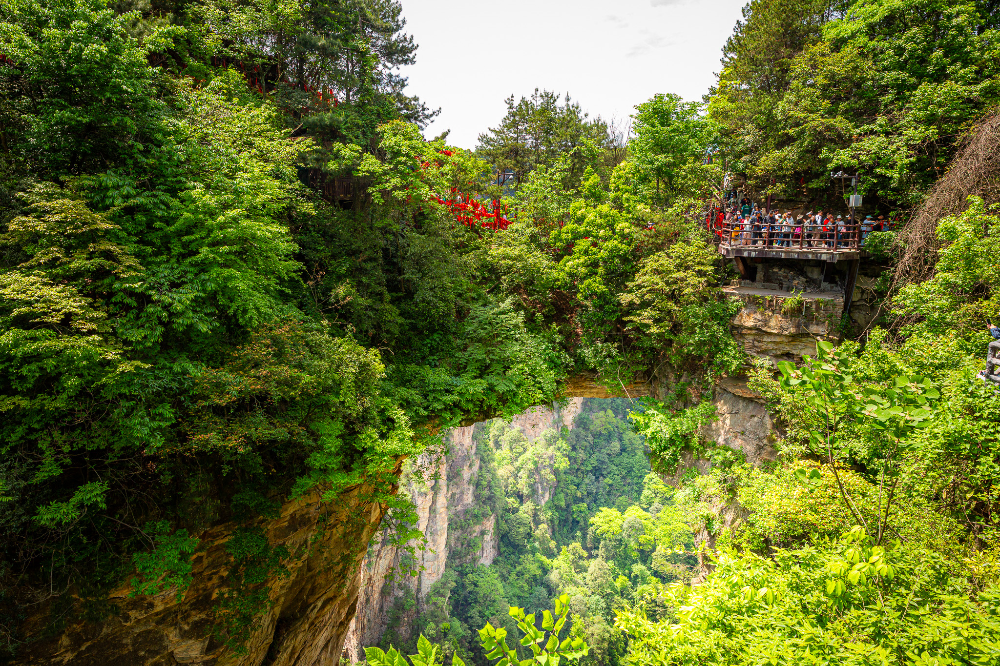 Prírodný kamenný most obrqastený zeleňou, First Bridge Under Heaven